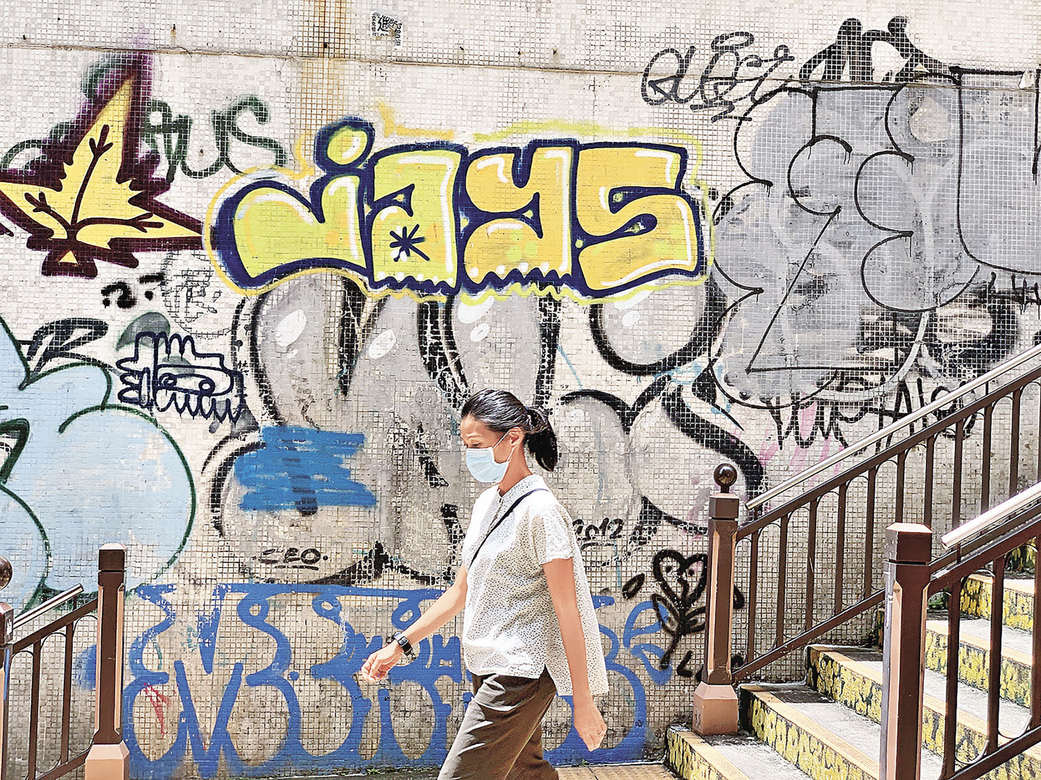 ■市民途經眾坊街一道畫滿塗鴉的牆。（Yau Ma Tei  油麻地）