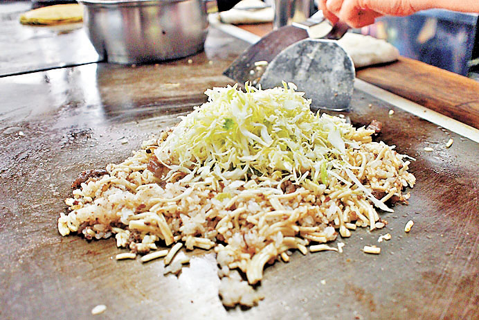 ■將中華麵和白飯在鐵板上拌炒後，再加進醬料做成的料理—神戶平民炒麵飯。