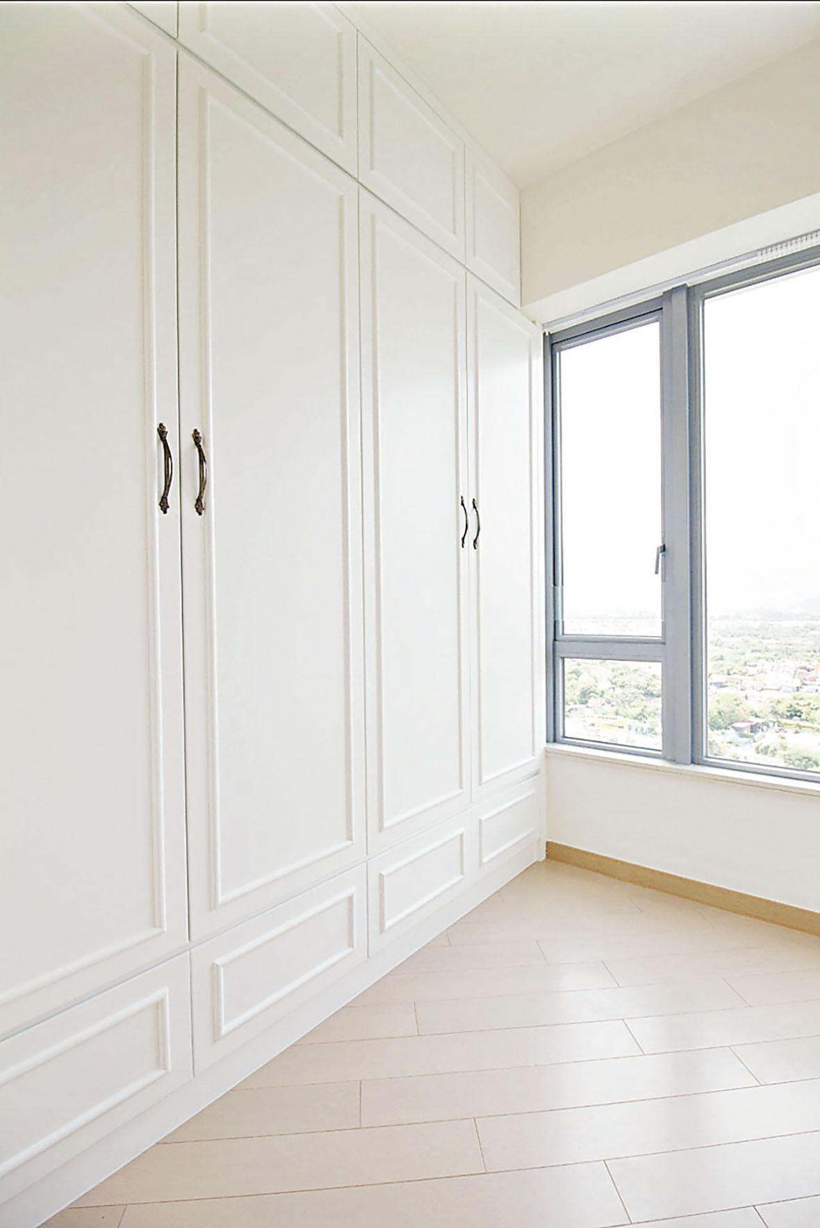 ■睡房高身白色衣櫃，配以藍色窗框。