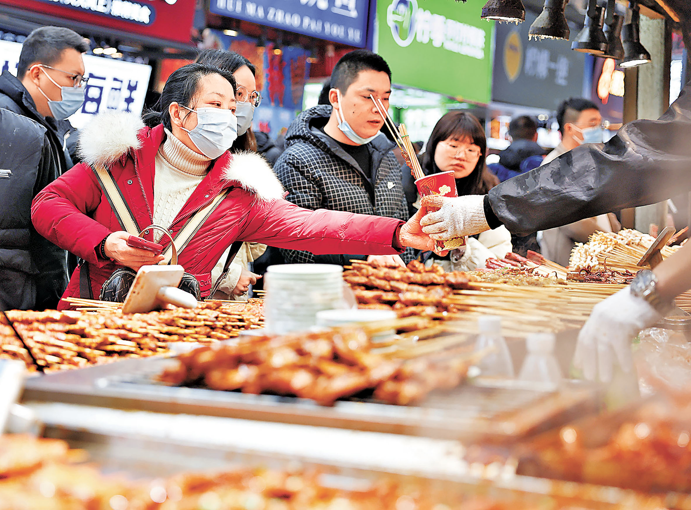 ■不少遊客在內地的步行街「掃碼」選購美食。