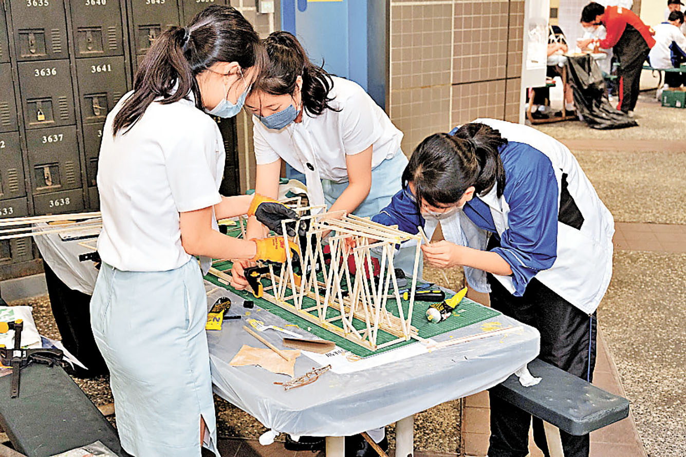 ■巾幗不讓鬚眉，女同學努力製作木製模型。