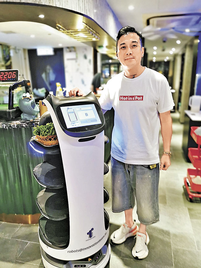 ■老闆梁志偉引入智能機械人運送食物。