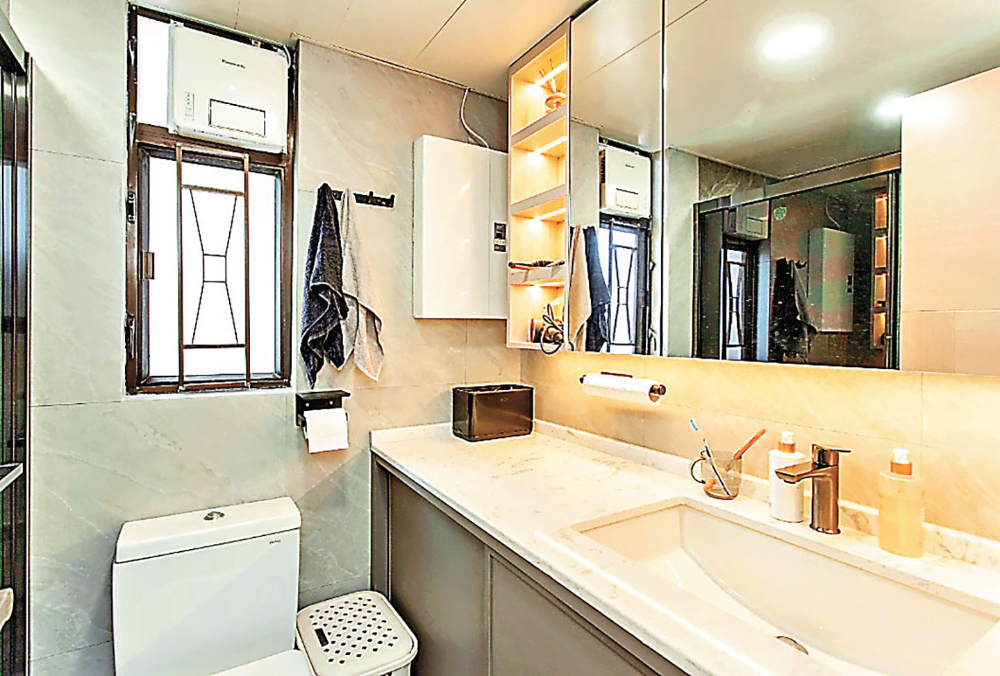 ■浴室的梳洗收納櫃枱配以玻璃裝飾吊櫃。