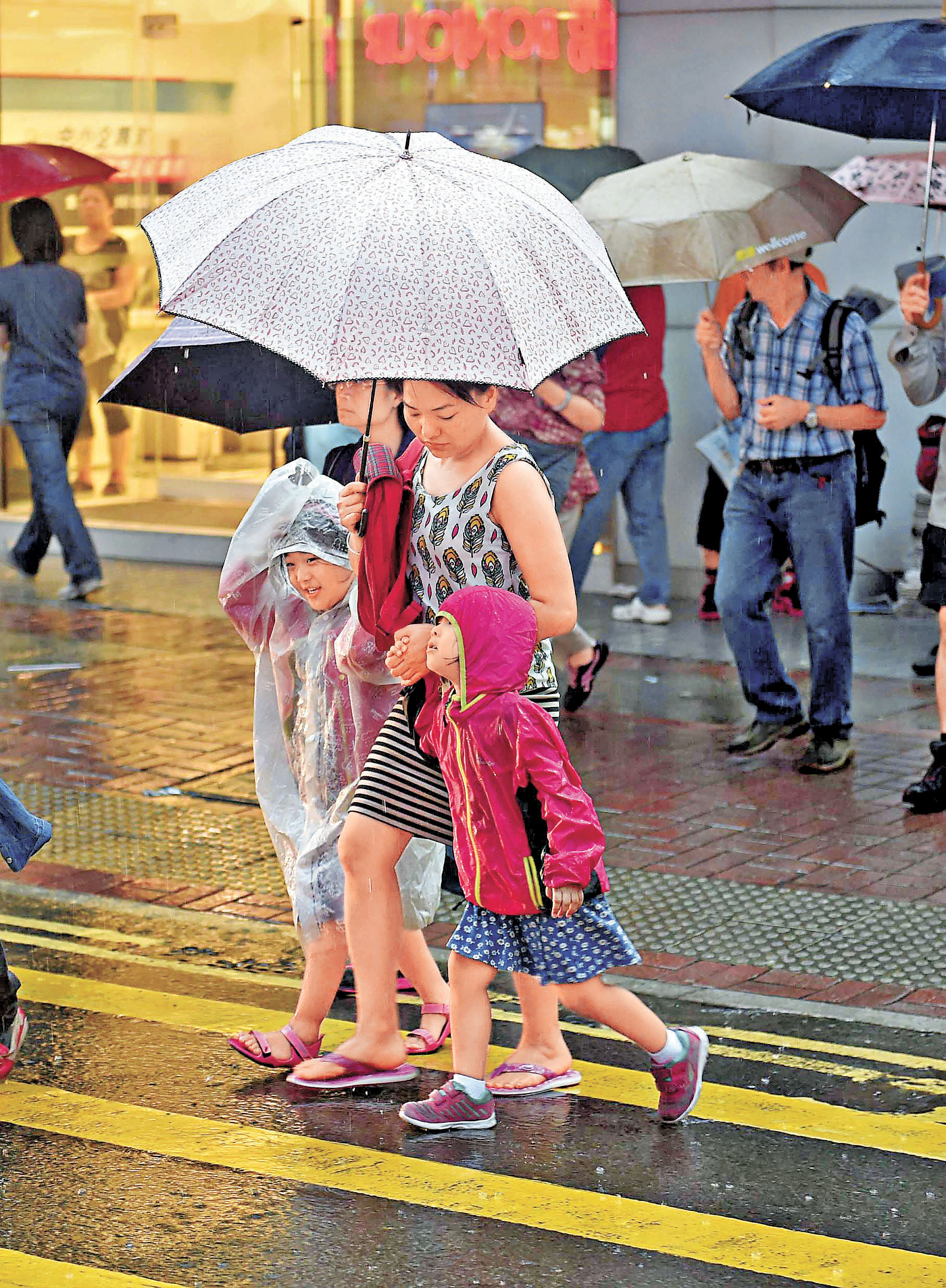 ■大雨之下，家長送子女返學十分狼狽。 資料圖片