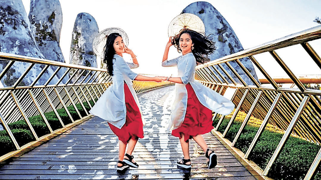 ■越南當地一對姊妹花在佛手橋前留影。