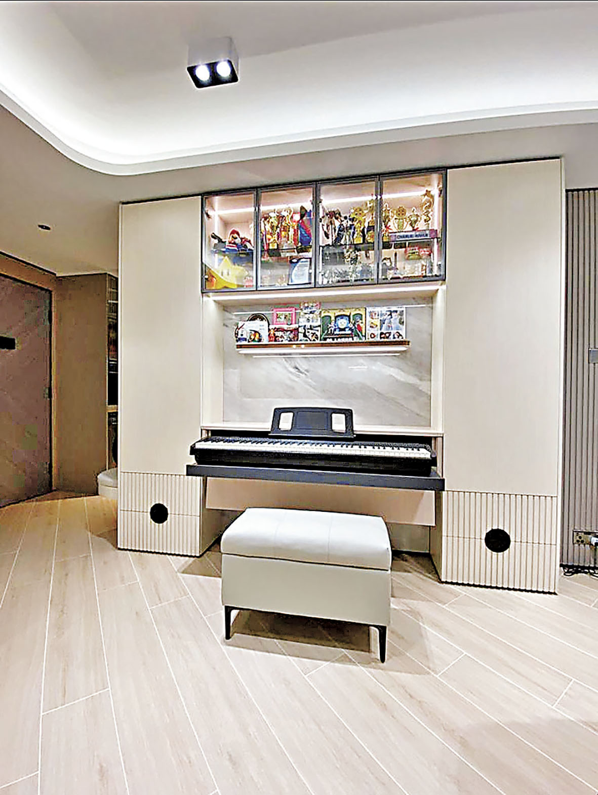 ■大廳一幅牆身，放置了玻璃飾櫃，收藏漫畫英雄公仔和一台鋼琴。