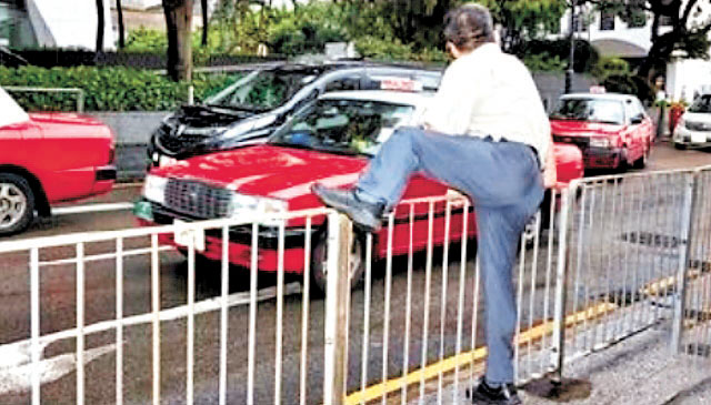 ■攀越道路分隔圍欄屬於違法行為。    運輸署圖片