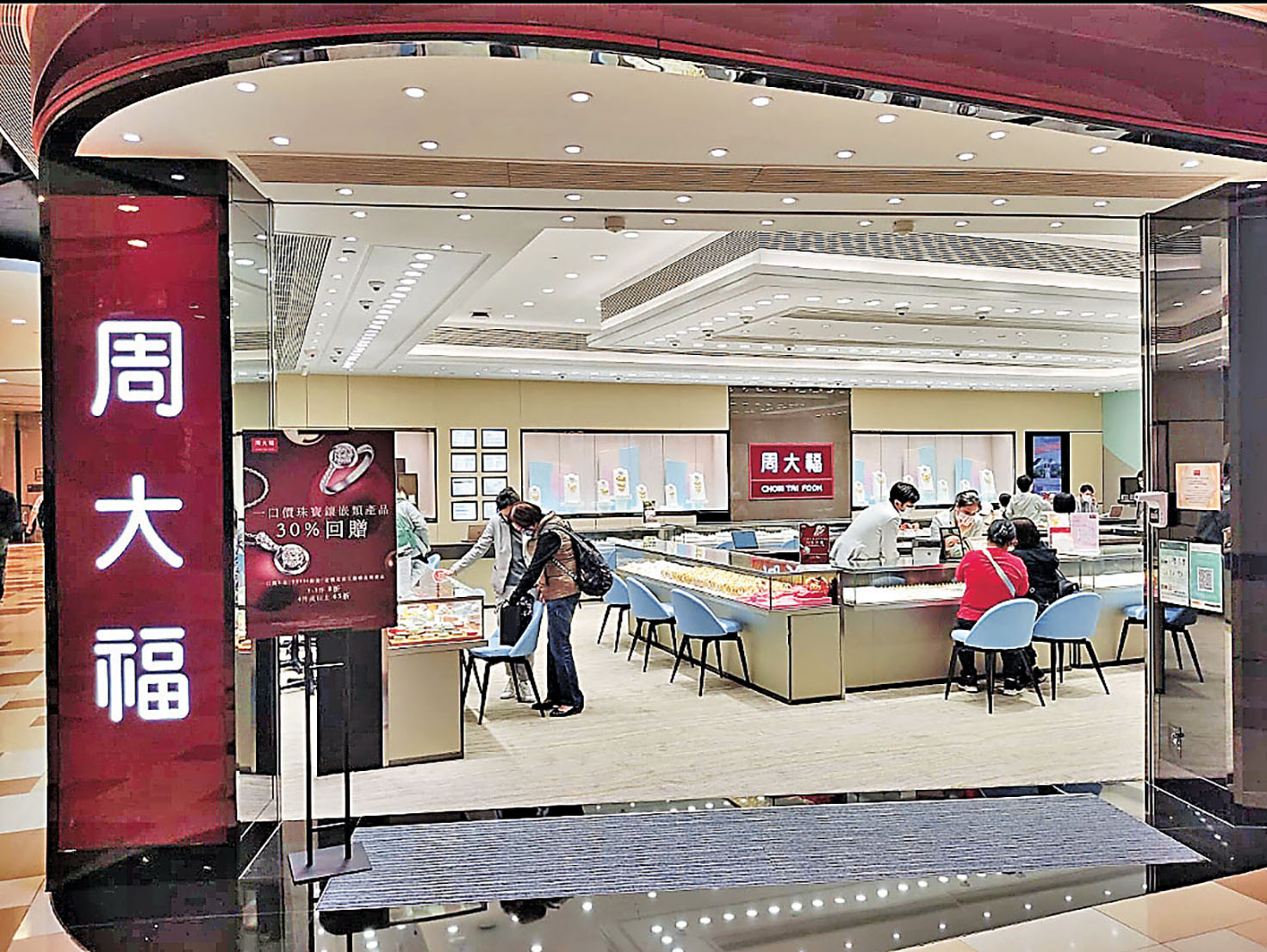 ■周大福分店內，客人正細心挑選金飾。