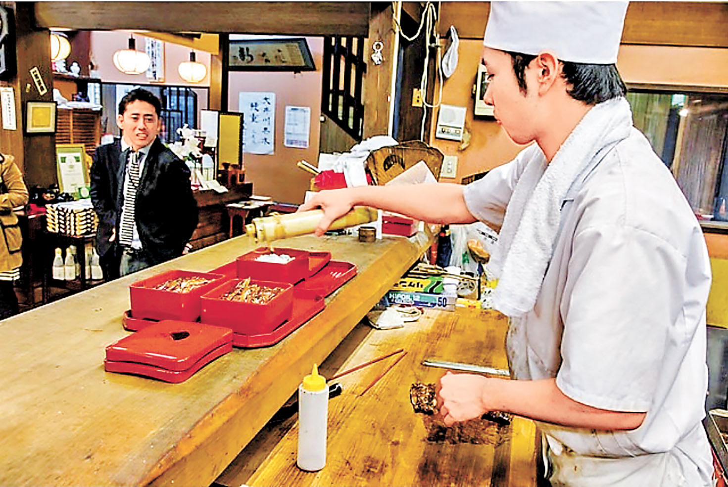■駿河屋師傅正為燒鰻魚飯淋上醬汁。