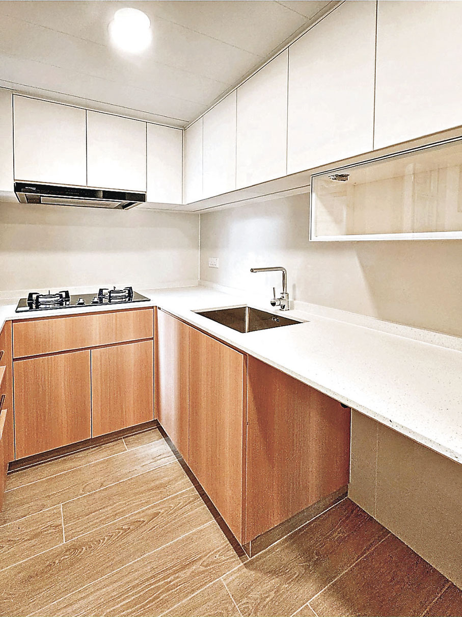 ■廚房下方的廚櫃及地板與白色吊櫃和廚枱形成強烈對比。