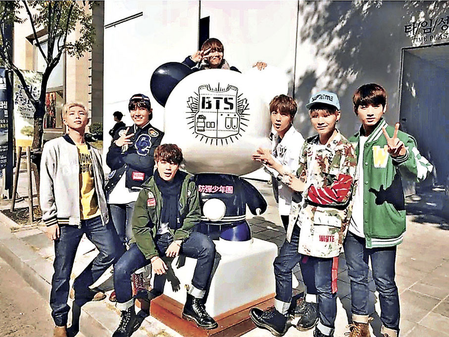 ■韓國男團BTS在韓星街上的BTS吉祥物旁打卡。