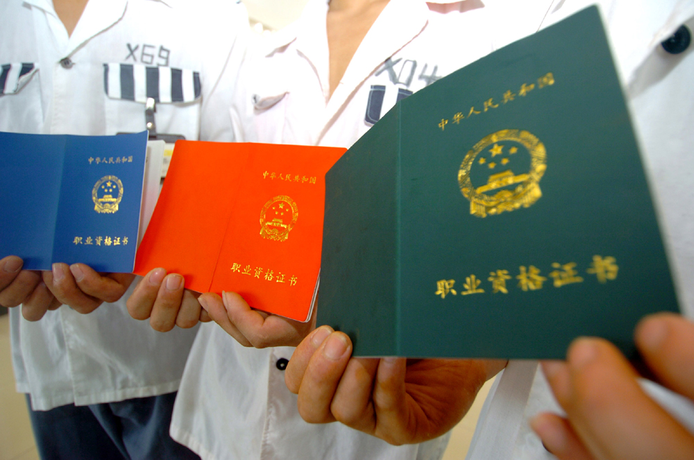 　　圖：十八日，服刑人員在展示獲得的職業資格證書（新華社）