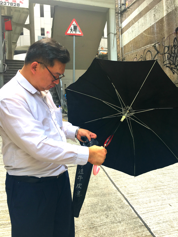   圖：何國基介紹其父首創的牛皮遮/大公報實習記者李欣欣攝