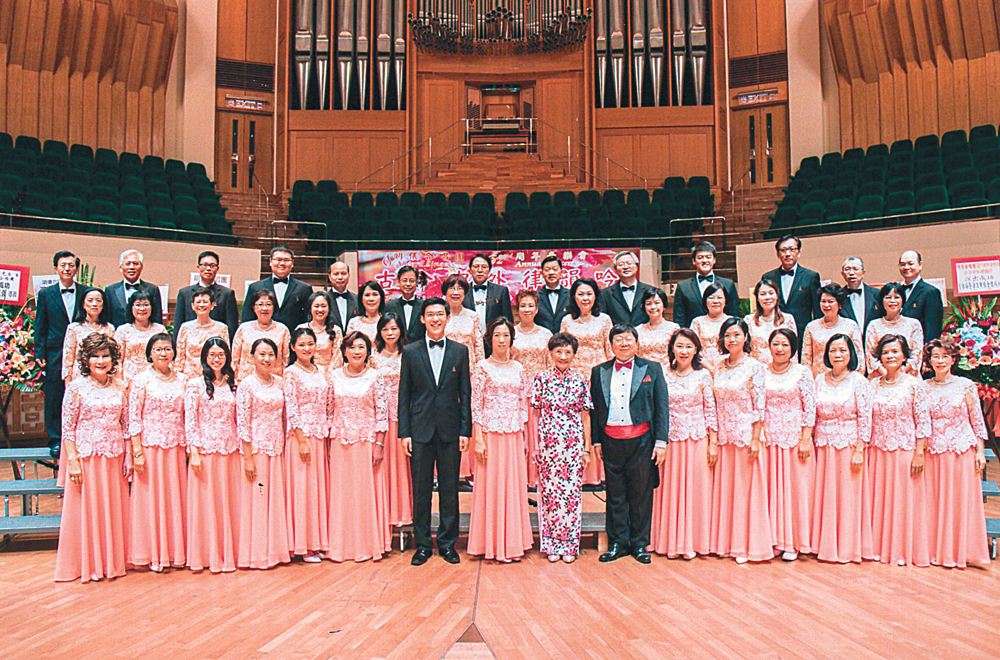   圖：去年「明儀合唱團52周年音樂會│古今中外律韻吟」在香港文化中心舉行，費明儀（首排右八）與眾演出人員合影  資料圖片
