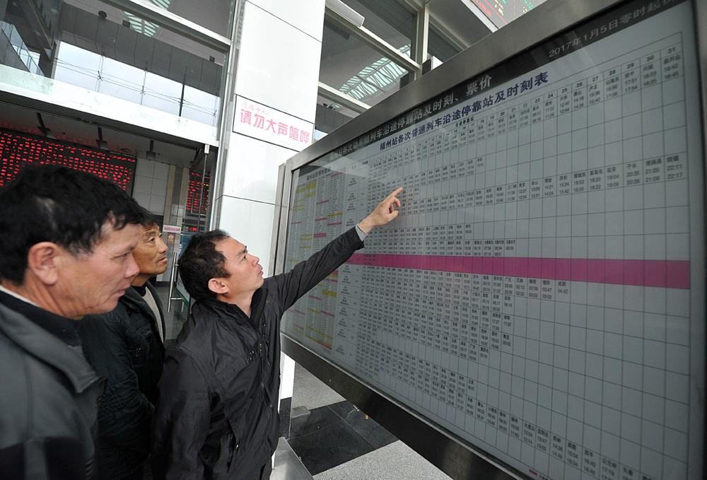   圖：5日，準備出行的民眾在福州火車站察看最新的列車時刻表 中新社