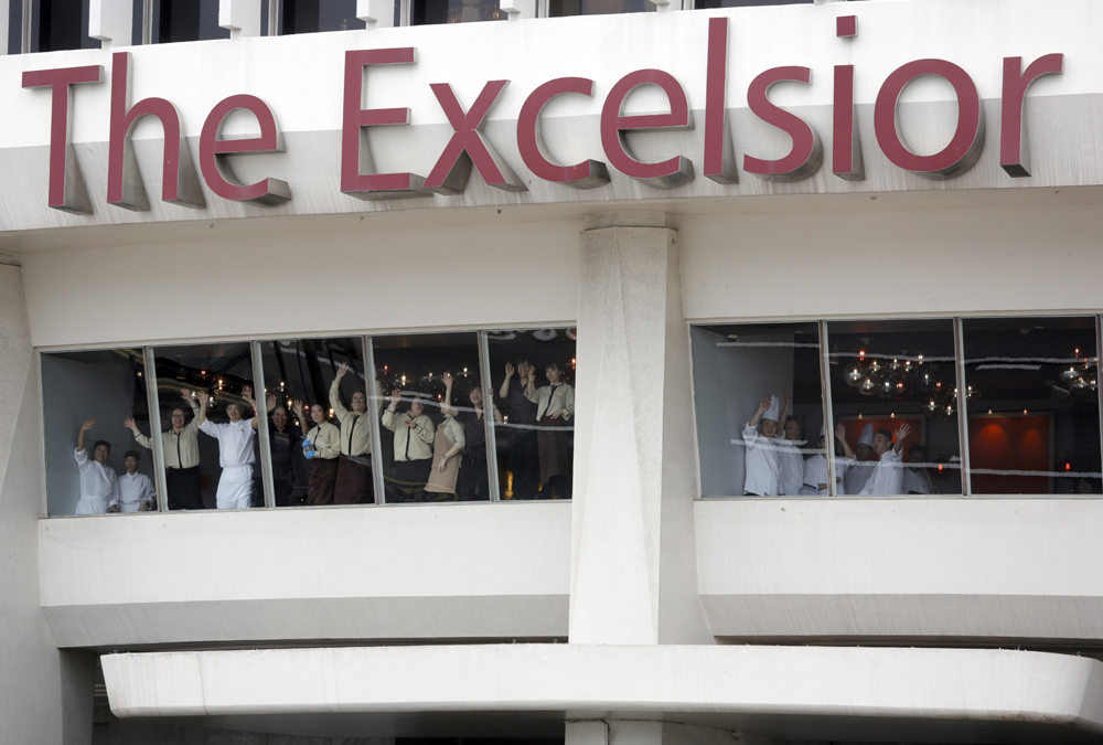 　　圖：怡東酒店昨午十二時正式結業，員工笑中帶淚揮手道別