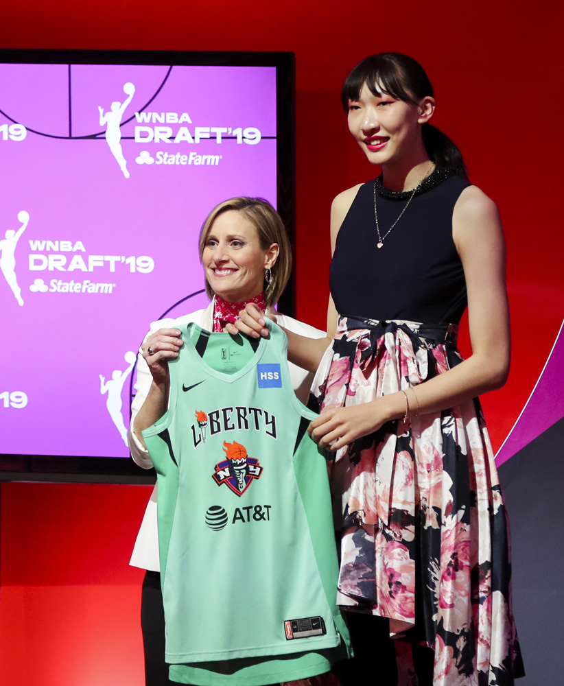 　　圖：韓旭（右）在選秀大會上從WNBA首席運營官赫奇佩思手中接過紐約自由人隊球衣\新華社