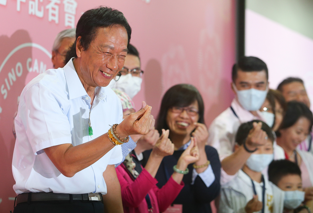 　　圖：鴻海集團董事長郭台銘（左）11日出席永齡健康基金會舉辦的永齡華人抗癌聯合行動周年記者會，與病友及家屬等人比愛心合影\中央社