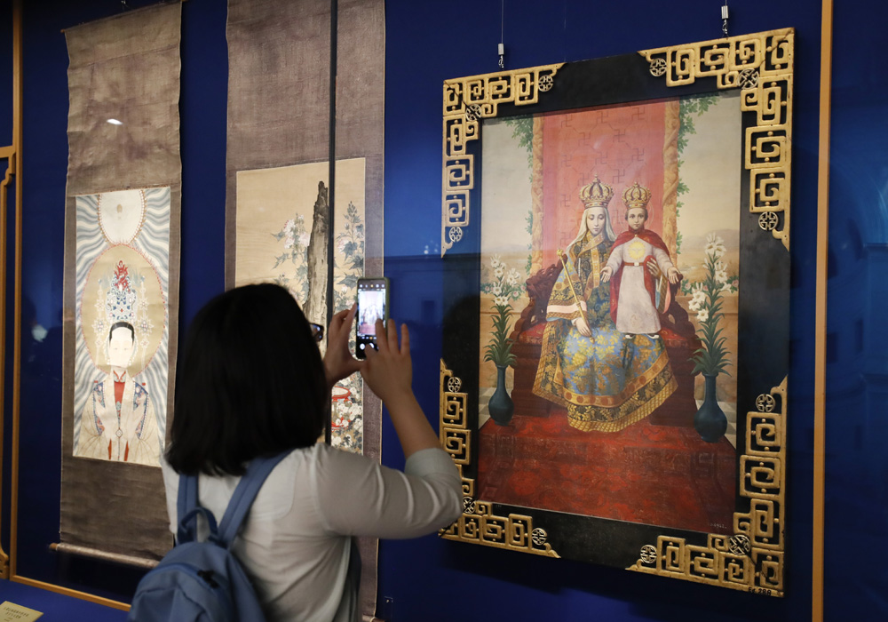 　　圖：參觀者用手機拍攝中華聖母畫像（1924年）/中新社