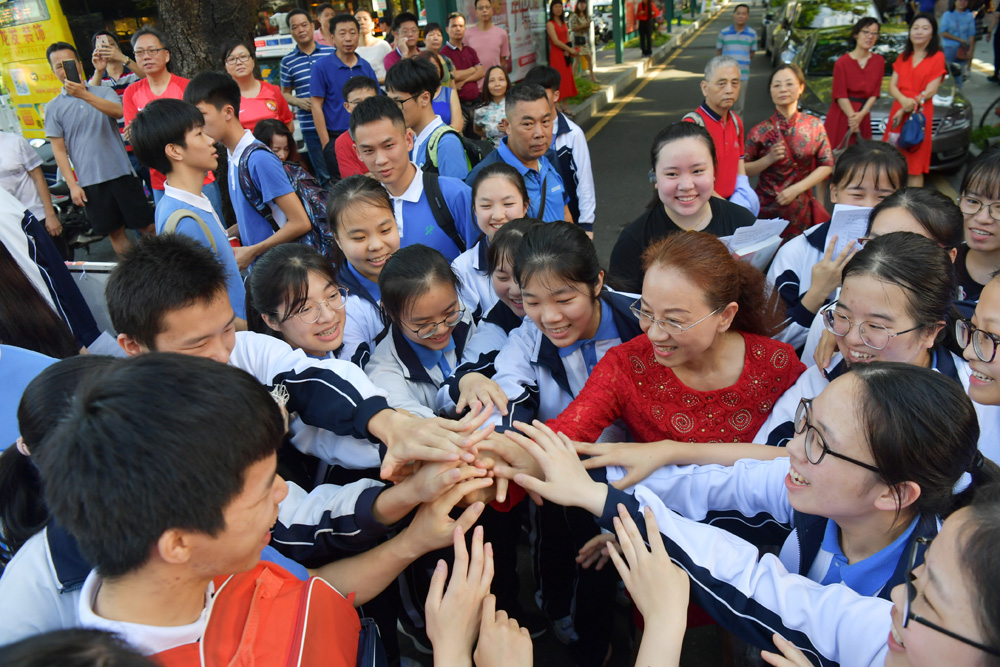 　　圖：6月7日，在2019年全國高考深圳市福田中學考點，老師與考生一起加油\中新社