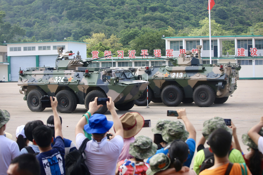 　　圖：裝甲車魚貫進場，揚起沙塵和逼真的炮火聲，引發市民一陣歡呼