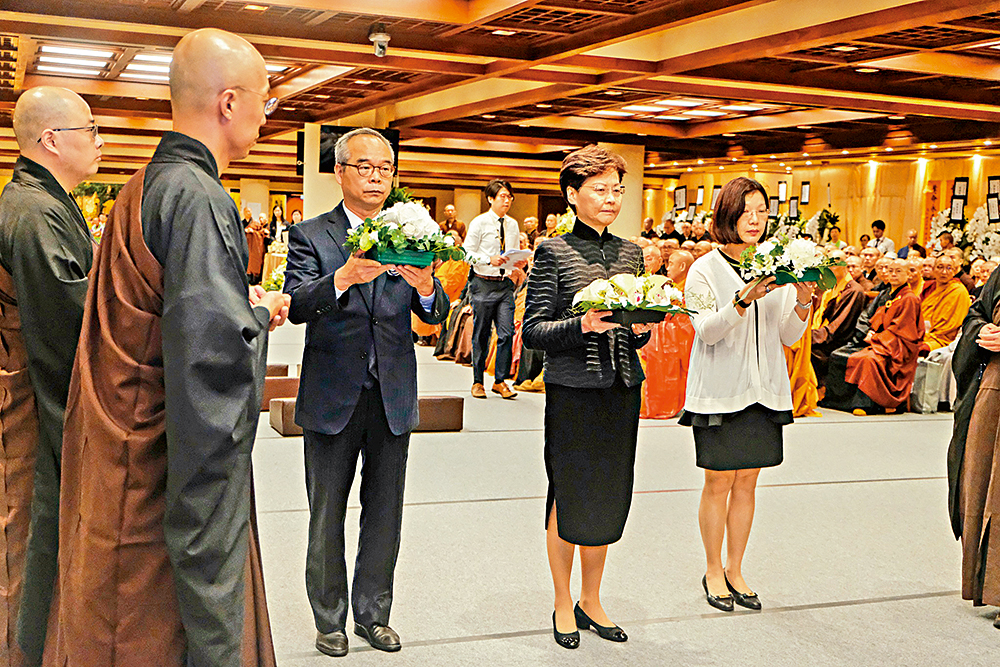 　　圖：行政長官林鄭月娥（中）、民政事務局局長劉江華（左）、民政事務總署署長謝小華（右）在儀典上獻花