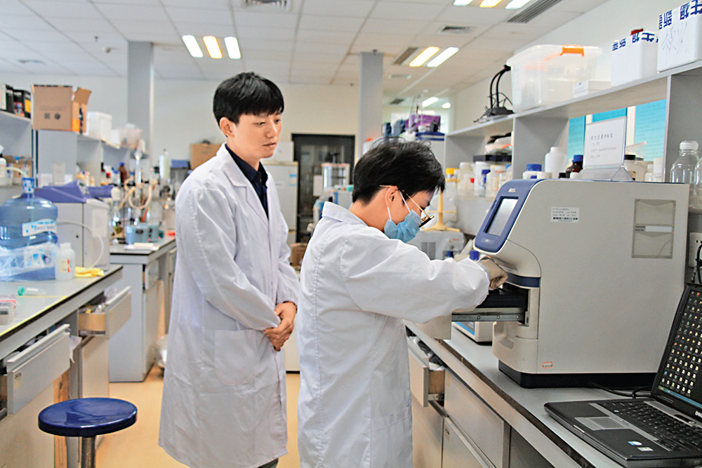 　　圖：香港城市大學博士團隊在腫瘤液體活檢技術方面取得突破，成功在大灣區落地生產。圖為晶准醫學CEO徐濤（左）與工作人員在實驗室\大公報記者何花攝