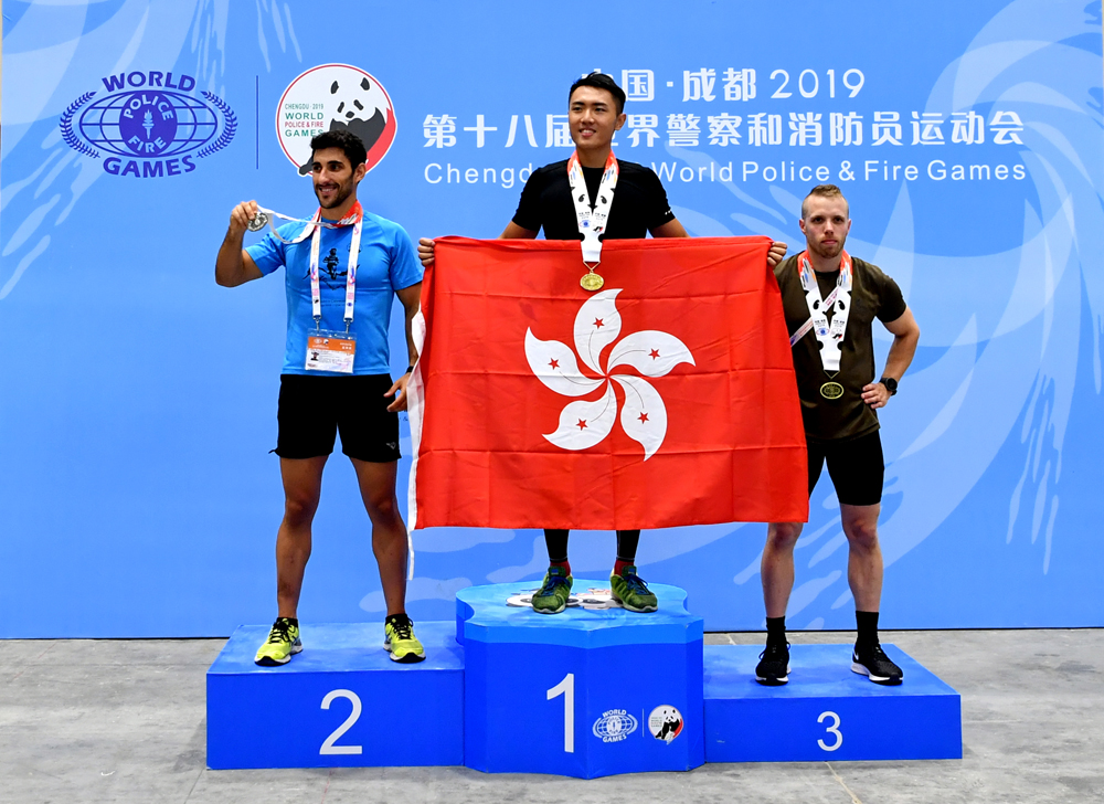 　　圖：9日，第十八屆世界警察和消防員運動會迎來第一個比賽日。香港警察黃瑋樂（中）在室內划艇2000米輕量級比賽中獲得金牌\中新社