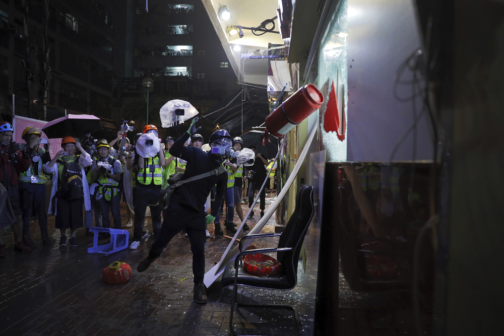 　　圖：暴徒在荃灣二陂坊飛擲滅火筒，掟爆一間麻雀館的大玻璃