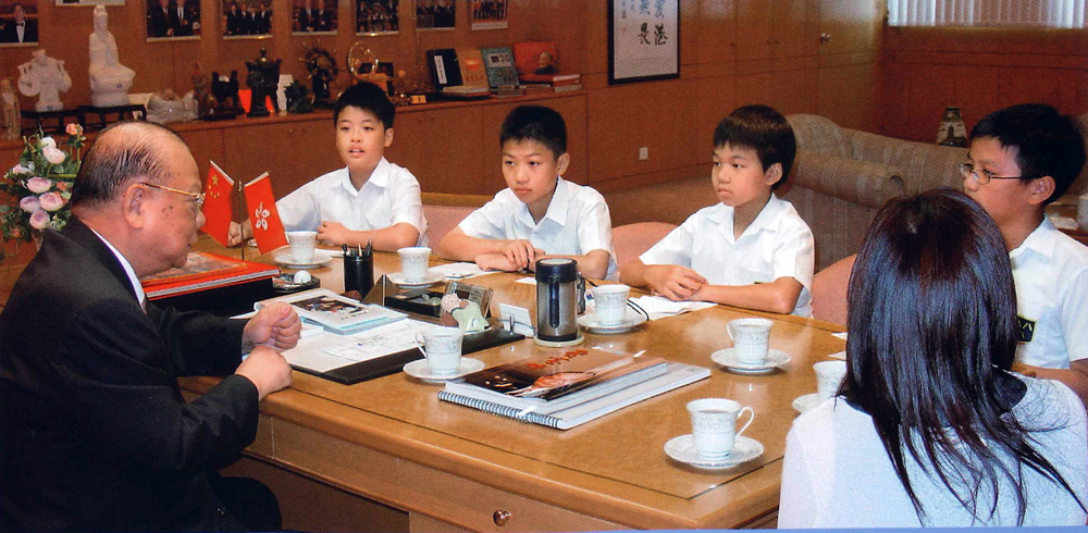 　　圖：曾憲梓熱心教育，與香港小學生親切交談