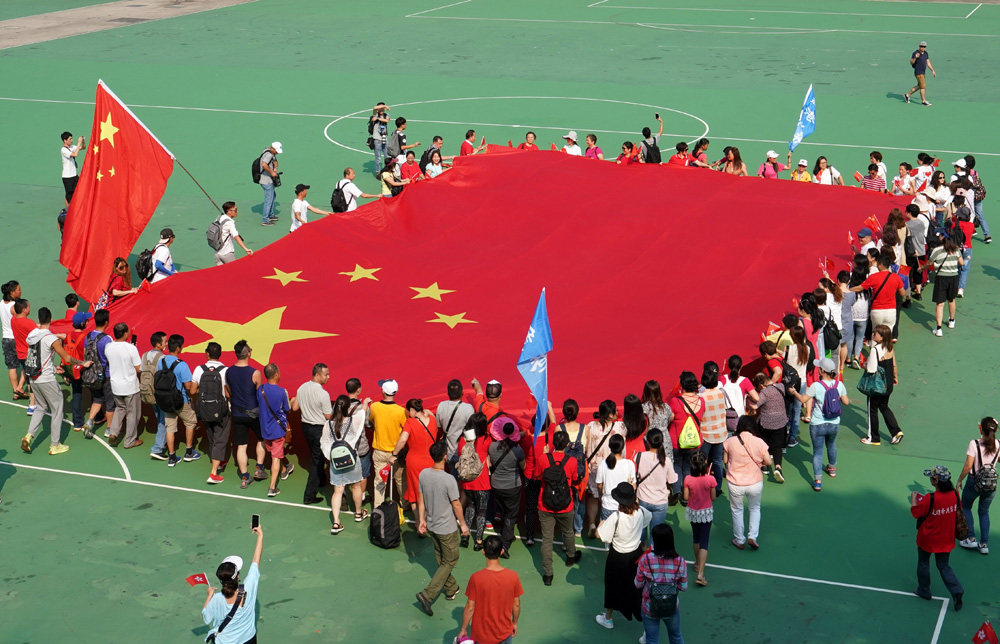 　　圖：120市民在維園高舉巨幅國旗，高唱《歌唱祖國》\中新社