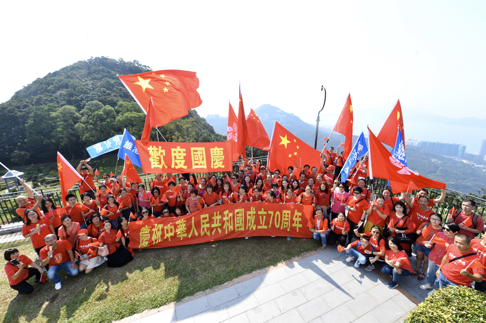 　　圖：近百名愛國愛港人士登上太平山頂揮動五星紅旗，高唱國歌\中新社