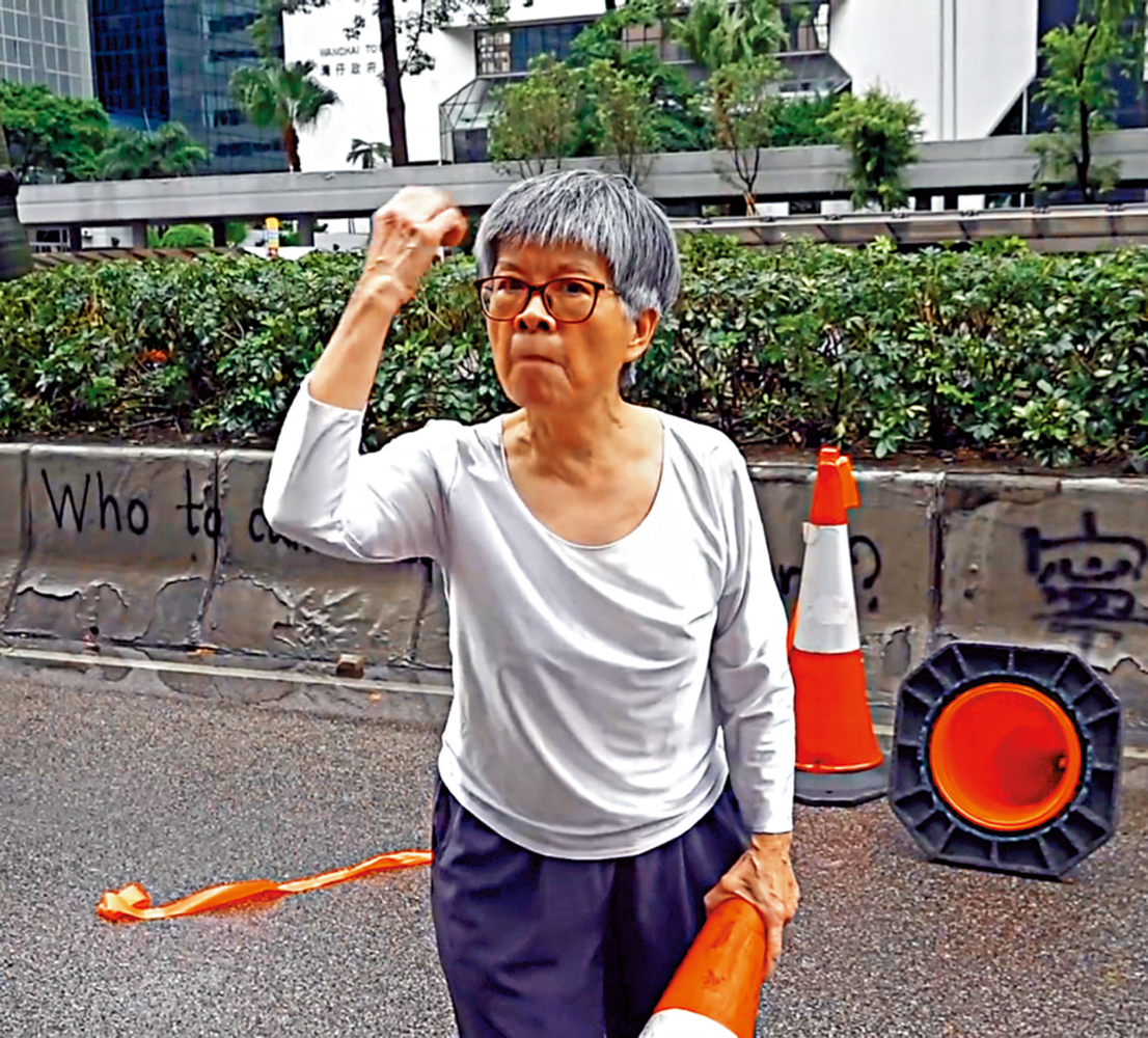 　　圖：70歲婆婆面無懼色，當着暴徒的面把路障一個個搬開，並怒斥暴徒惡行