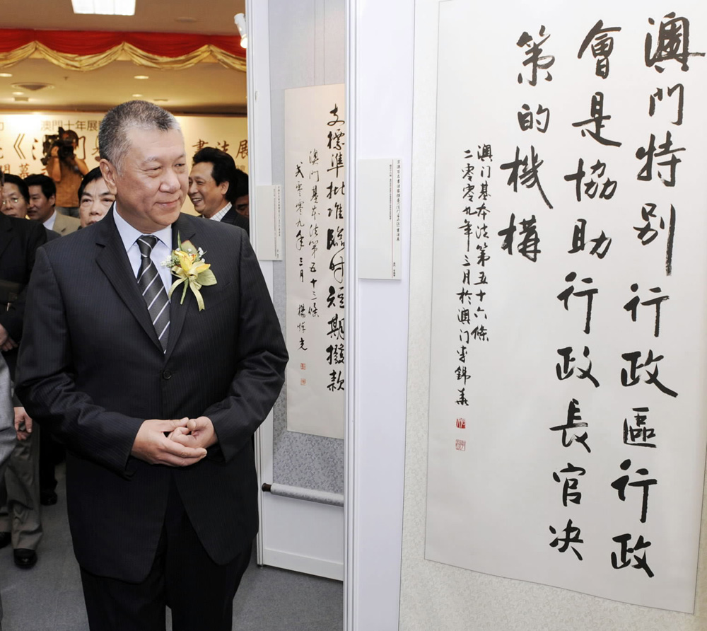 　　圖：2009年5月7日，何厚鏵觀看書寫澳門基本法條文的書法作品/資料圖片