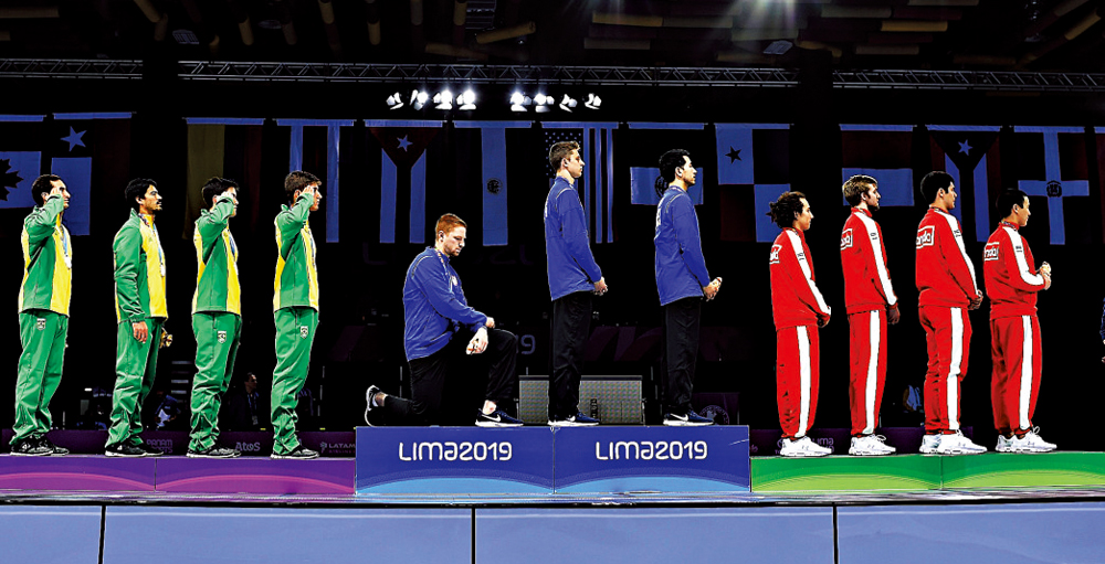 　　圖：美男子擊劍運動員英博登（左四）去年8月在秘魯泛美運動會頒獎台上單膝下跪抗議\美聯社