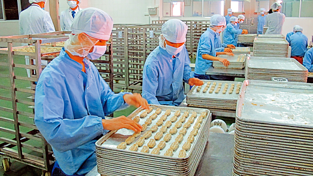 　　圖：在廣東一食品工廠車間，員工戴上口罩生產\大公報記者盧靜怡攝 