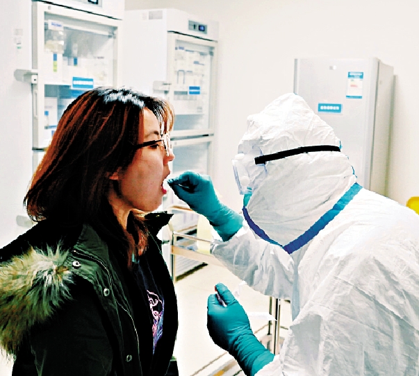 　　圖：工作人員在檢測咽拭子\受訪者供圖