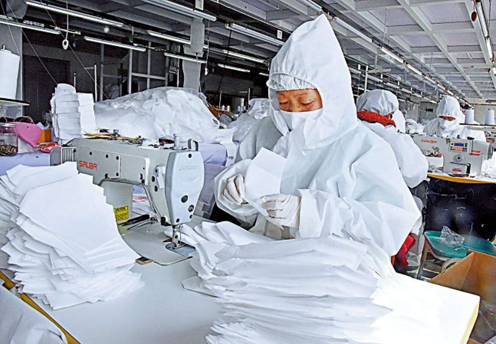 　　圖：2日，青島一家服裝轉產企業在生產防護口罩/新華社