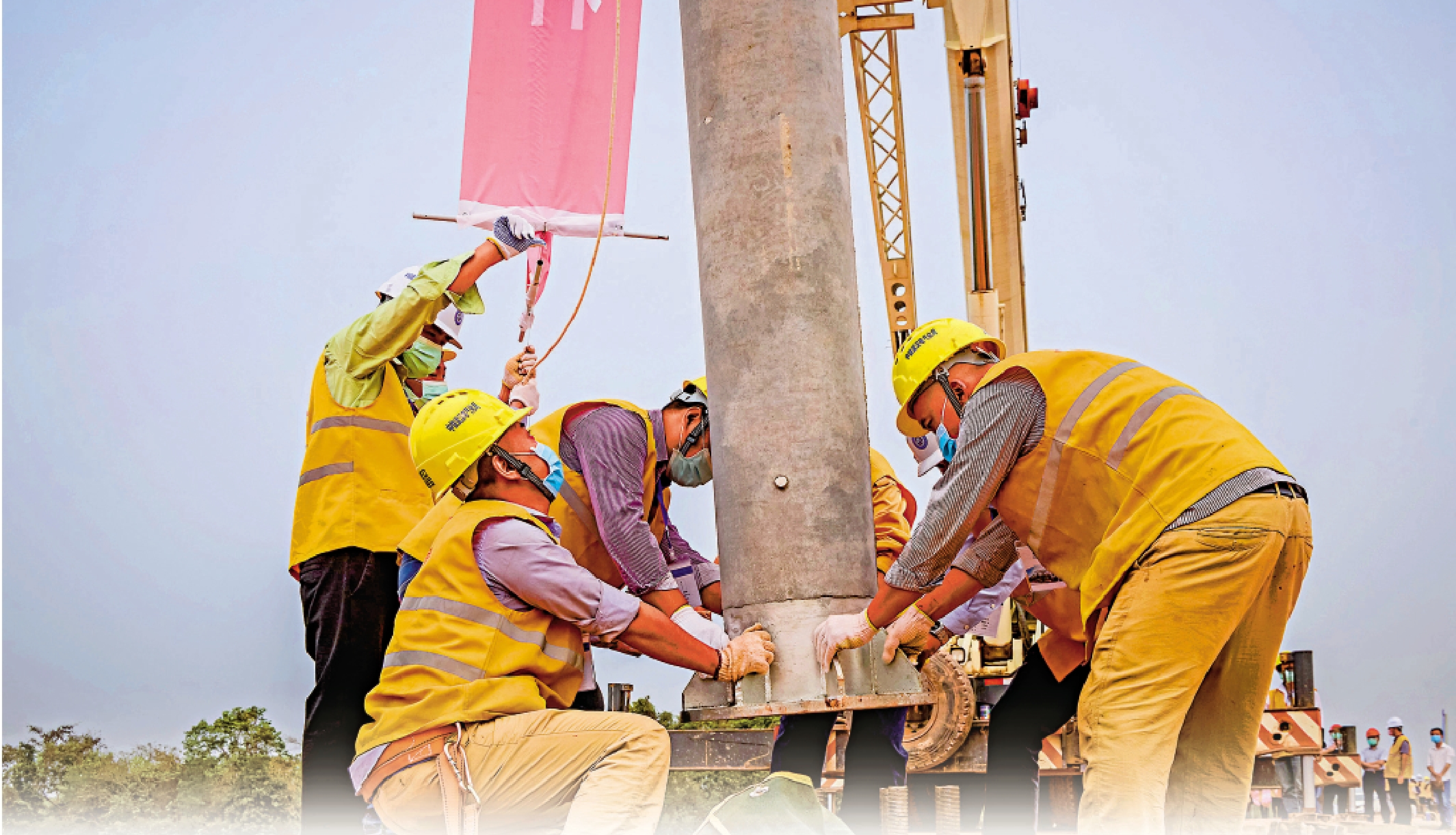 　　圖：3月15日，在老撾首都萬象北部的中老鐵路項目工地，工人豎立電氣化接觸網桿　　  新華社
