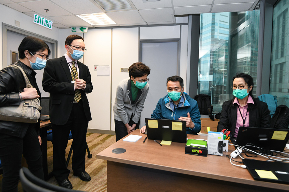 　　圖：林鄭月娥（中）昨日到訪政府資訊科技總監辦公室（資科辦）在北角政府合署新設立的家居檢疫控制中心，為辛勤工作的資科辦人員和參與抗疫工作的廉政公署人員打氣。旁為創新及科技局常任秘書長蔡淑嫻（左一）和政府資訊科技總監林偉喬（左二）