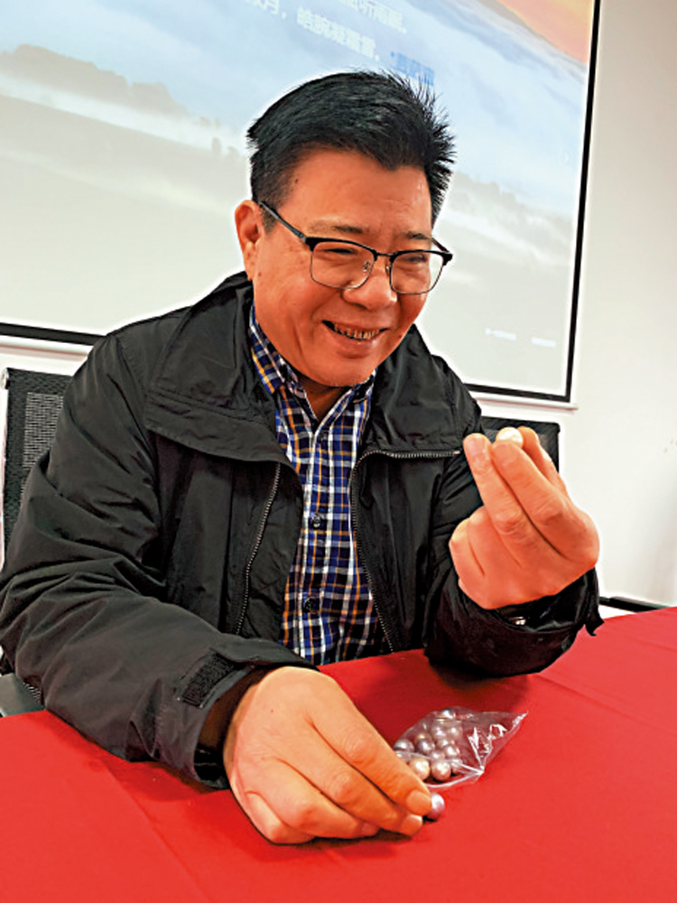 　　圖：傅百成興奮地向記者展示珍珠