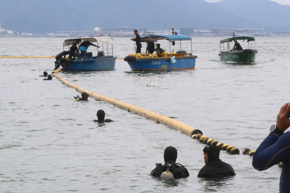 　　圖：八名康文署外判潛水員到泳灘找尋鯊魚及檢查防鯊網\大公報突發組攝