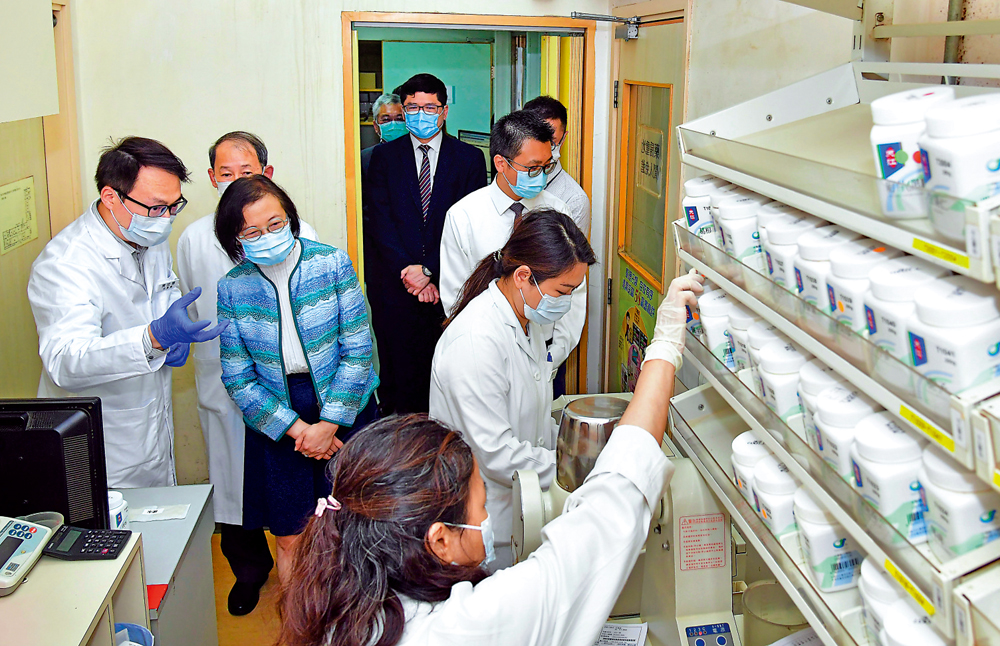 　　圖：陳肇始（左三）早前到訪大埔那打素醫院的中醫診所，聽取職員介紹中藥顆粒沖劑配發流程