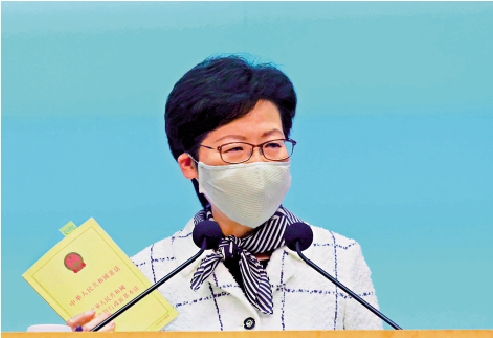　　圖：林鄭月娥手持一本基本法指出，基本法寫明，香港特別行政區是中華人民共和國不可分離的一部分，香港特別行政區享有高度自治，但特區直轄於中央人民政府