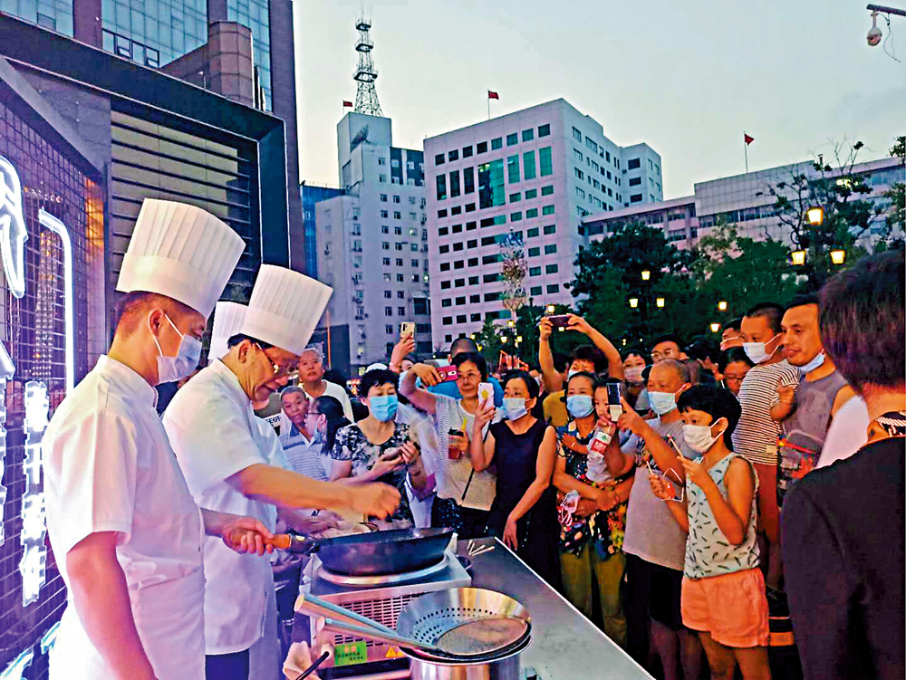　　圖：國家級非物質文化遺產代表性項目傳承人、遼菜大師劉敬賢（左二）在八卦街夜市中現場製作「鹿鳴肉丸」\大公報記者于珈琳攝