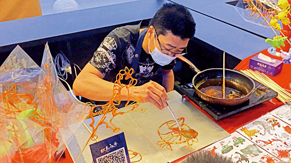 　　圖：具有近百年歷史的馬氏糖畫傳承人馬斌在夜市中現場製作糖人\大公報記者于珈琳攝