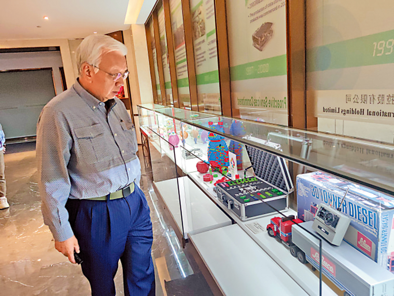 　　圖：何焯輝細看公司過往的專利發明產品\大公報記者盧靜怡攝