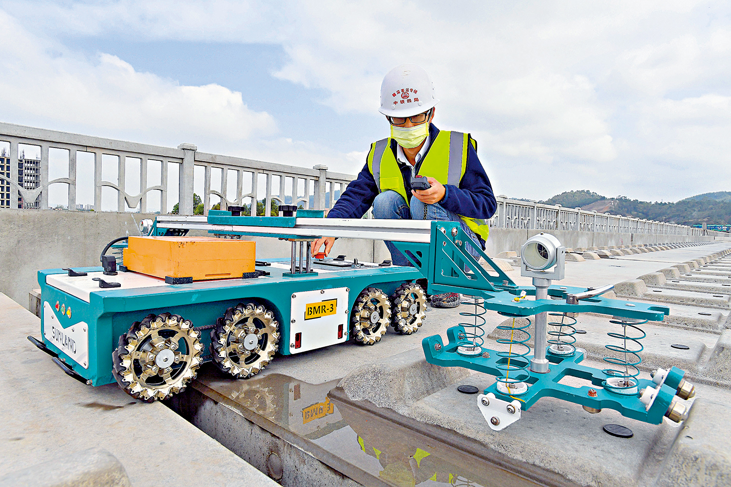 　　圖：自二○二一年一月一日起，香港工程建設企業和專業人士可在灣區內地九市開業執業。圖為工程師在高鐵軌道操作無砟軌道承載台檢測機器人對承載台進行檢測\資料圖片