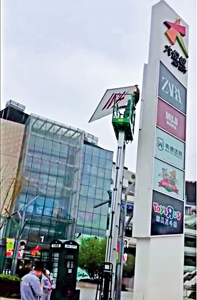 　　圖：3月25日，網傳一段影片中，工作人員拆除成都大悅城H&M商標。\視頻截圖