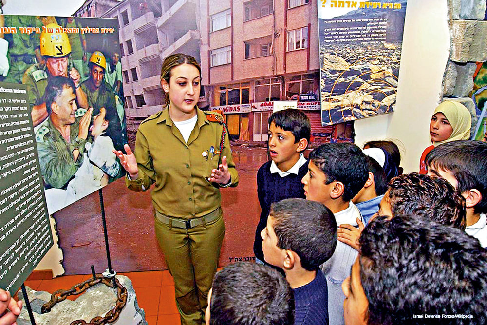 　　圖：以色列安全部隊成員為小朋友講解歷史圖片。\資料圖片